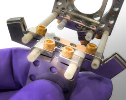 Example of a Groove Grabber Clamp engaging a eV Part Assembly. Screw clamps, Alumina tubing, Clamping Plate assemblies, and Series C plates are within the view. 